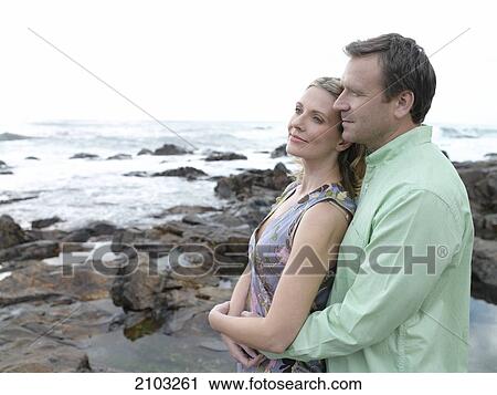 Side profile of couple standing at poolside View Large Photo Image Stock Image - Side profile of couple standing at poolside . Fotosearch