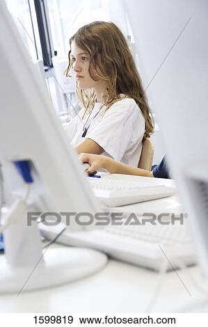 Stock Photo - Side profile of girl working on laptop . Fotosearch