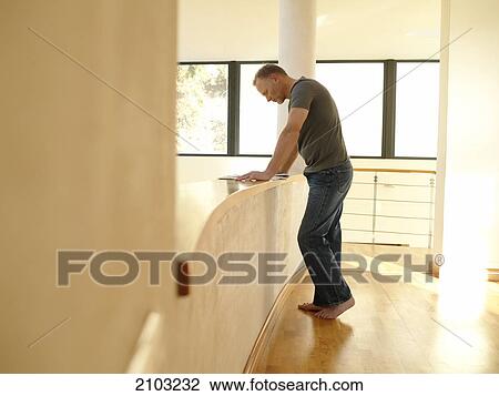 Side profile of man reading newspaper in corridor View Large Photo Image Stock Image - Side profile of man reading newspaper in corridor . Fotosearch