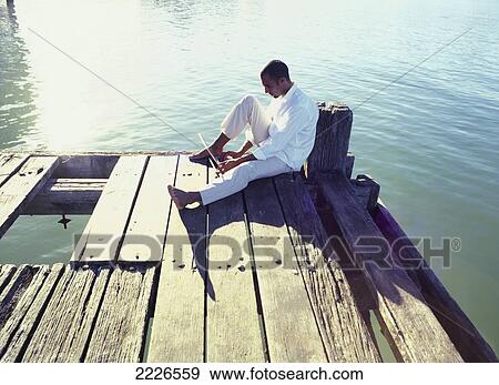 Side profile of man using laptop on pier View Large Photo Image Stock Photo - Side profile of man using laptop on pier . Fotosearch