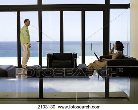 Side profile of woman looking at her husband standing near window  View Large Photo Image Stock Image - Side profile of woman looking at her husband standing near window . Fotosearch