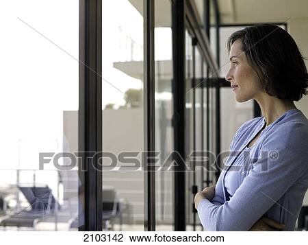 Side profile of woman looking through window View Large Photo Image Stock Image - Side profile of woman looking through window . Fotosearch