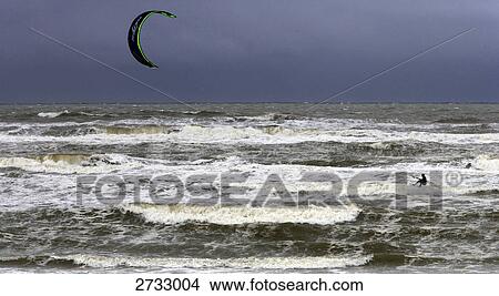 Picture - Silhouette of person kitesurfing in sea . Fotosearch