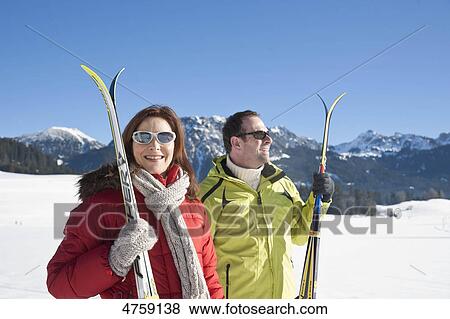 Smiling couple with skis in winter landscape, Tannheimer Tal, Tyrol, Austria View Large Photo Image Stock Photo - Smiling couple with skis in winter landscape, Tannheimer Tal, Tyrol, Austria . Fotosearch