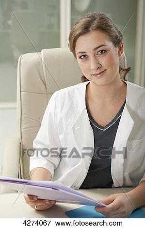 Stock Photo - Smiling doctor's assistant at desk in medical practice . Fotosearch