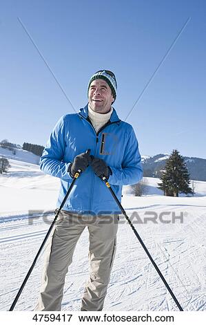 Stock Photo - Smiling man in winter landscape, Tannheimer Tal, Tyrol, Austria . Fotosearch