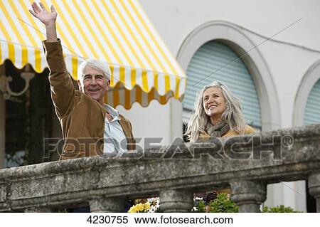 Stock Photography - Smiling senior couple behind railing, Italy, Gardone Riviera . Fotosearch
