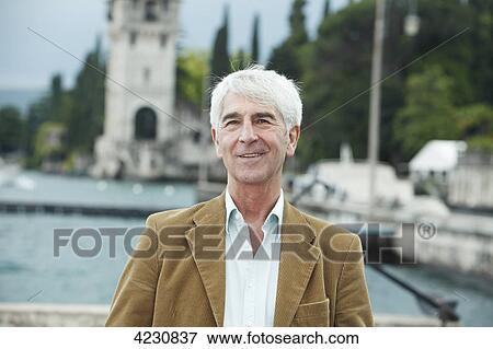 Stock Photo - Smiling senior man outdoors, Italy, Gardone Riviera . Fotosearch