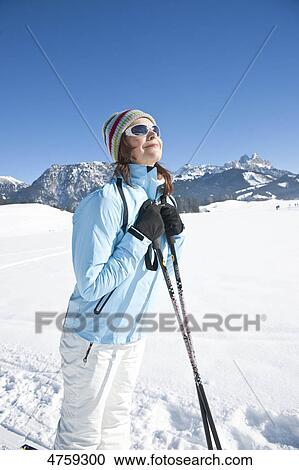 Stock Image - Smiling woman in winter landscape, Tannheimer Tal, Tyrol, Austria . Fotosearch