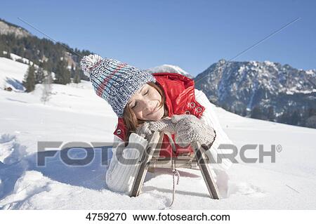 Smiling woman lying on toboggan, Tannheimer Tal, Tyrol, Austria View Large Photo Image Stock Image - Smiling woman lying on toboggan, Tannheimer Tal, Tyrol, Austria . Fotosearch