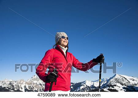 Stock Photo - Smiling woman with ski poles in winter landscape, Tannheimer Tal, Tyrol, Austria . Fotosearch