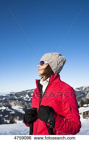 Stock Photograph - Smiling woman with ski poles in winter landscape, Tannheimer Tal, Tyrol, Austria . Fotosearch