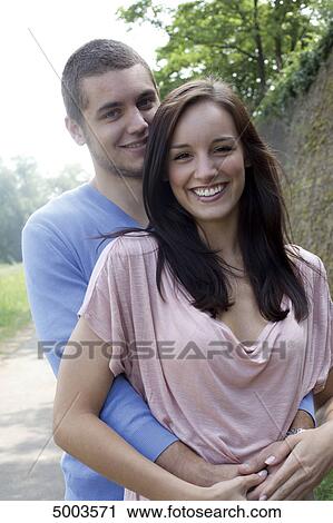 Stock Image - Smiling young couple outdoors . Fotosearch