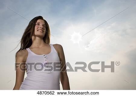Stock Image - Smiling young woman outdoors . Fotosearch