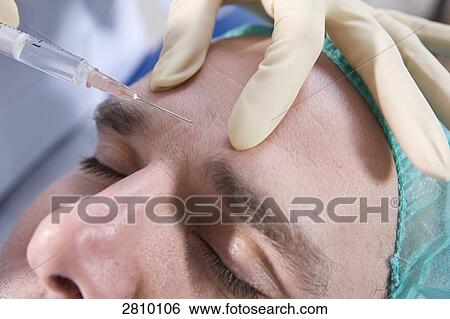 Surgeon injecting into forehead of patient View Large Photo Image Stock Photograph - Surgeon injecting into forehead of patient . Fotosearch
