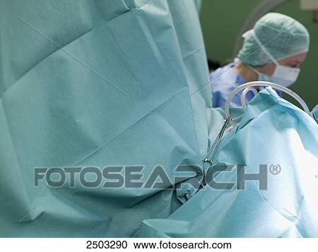 Stock Image - Surgeon performing operation in operating room . Fotosearch