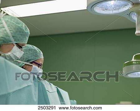 Stock Image - Surgeons in operating room . Fotosearch