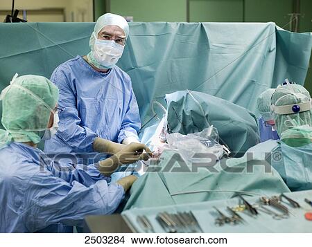 Surgeons performing operation in operating room View Large Photo Image Picture - Surgeons performing operation in operating room . Fotosearch