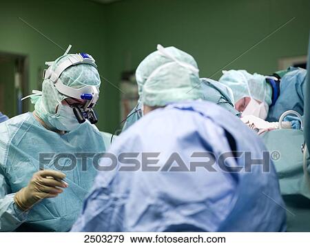 Surgeons performing operation in operating room View Large Photo Image Stock Photo - Surgeons performing operation in operating room . Fotosearch
