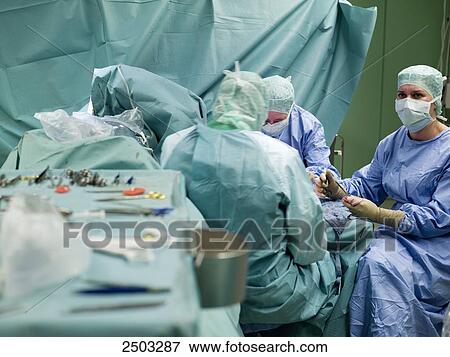 Stock Photo - Surgeons performing operation in operating room . Fotosearch