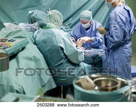 Surgeons performing operation in operating room View Large Photo Image Stock Photo - Surgeons performing operation in operating room . Fotosearch