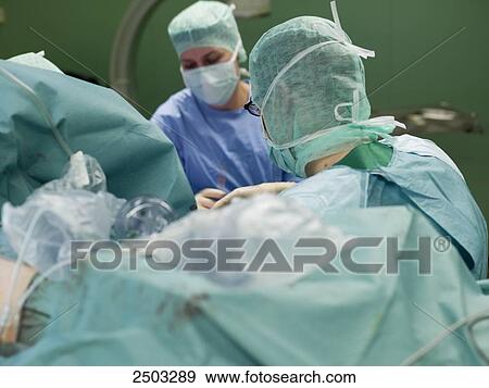 Surgeons performing operation in operating room View Large Photo Image Stock Photo - Surgeons performing operation in operating room . Fotosearch