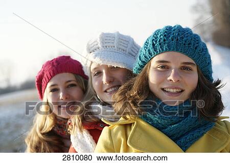 Stock Image - Teenage girls smiling in warm clothing . Fotosearch