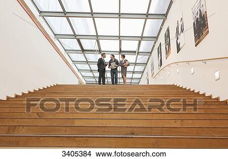 Three business people going downstairs View Large Photo Image Picture - Three business people going downstairs . Fotosearch