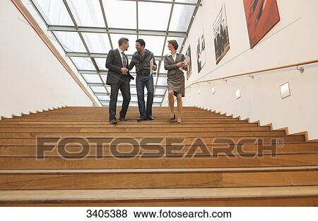 Three business people going downstairs View Large Photo Image Stock Photo - Three business people going downstairs . Fotosearch