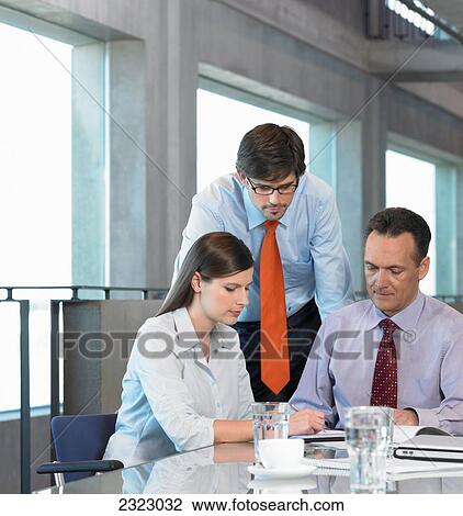 Stock Image - Three businesspeople discussing in meeting . Fotosearch