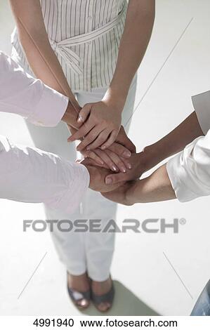 Three businesspeople laying their hands on each other View Large Photo Image Stock Image - Three businesspeople laying their hands on each other . Fotosearch