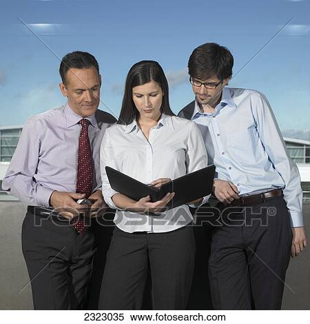 Stock Photography - Three businesspeople looking at file . Fotosearch