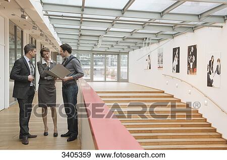 Three people standing in office building View Large Photo Image Stock Photo - Three people standing in office building . Fotosearch