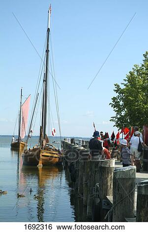 Tourists and sailboats at harbor View Large Photo Image Stock Photograph - Tourists and sailboats at harbor . Fotosearch