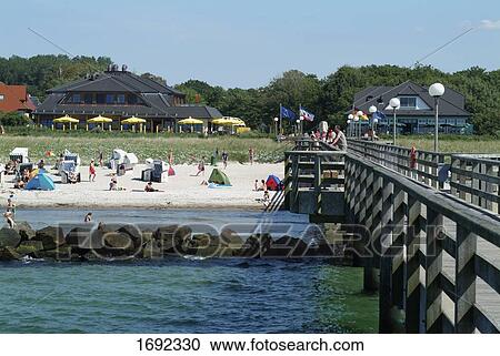 Stock Image - Tourists and wicker beach chairs on beach . Fotosearch