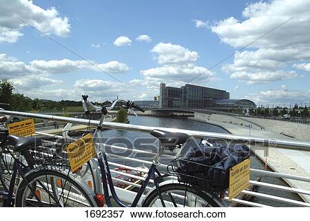 Stock Photo - Two bicycles leaning against railing of bridge . Fotosearch