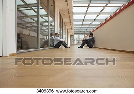 Two business men sitting on floor View Large Photo Image Stock Photograph - Two business men sitting on floor . Fotosearch