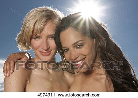 Two happy young women under blue sky View Large Photo Image Stock Image - Two happy young women under blue sky . Fotosearch