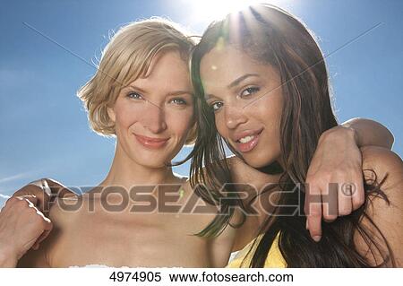 Two happy young women under blue sky View Large Photo Image Stock Photography - Two happy young women under blue sky . Fotosearch