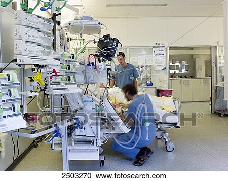 Stock Image - Two male doctors examining patient . Fotosearch