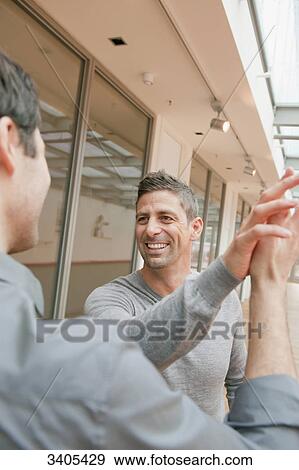 Two men giving high five View Large Photo Image Stock Photo - Two men giving high five . Fotosearch