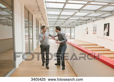 Stock Photography - Two men giving high five . Fotosearch