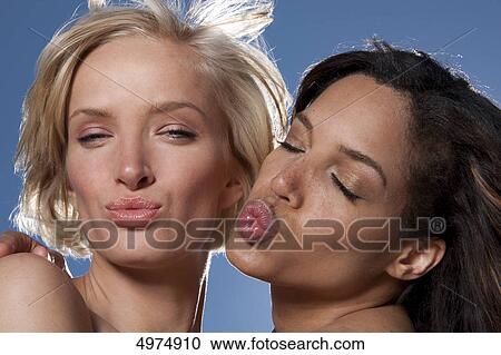 Two young women under blue sky pouting mouth View Large Photo Image Stock Image - Two young women under blue sky pouting mouth . Fotosearch