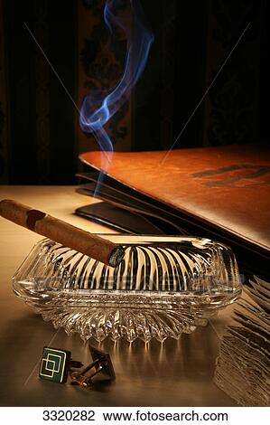 Stock Image - Unlit cigar in ashtray on a bedside table . Fotosearch