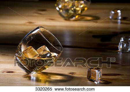 Whisky glasses and ice cubes on a wooden table View Large Photo Image Stock Photography - Whisky glasses and ice cubes on a wooden table . Fotosearch