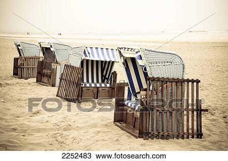 Stock Image - Wicker beach chairs on beach . Fotosearch