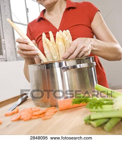Stock Photography - Woman cooking food in kitchen . Fotosearch