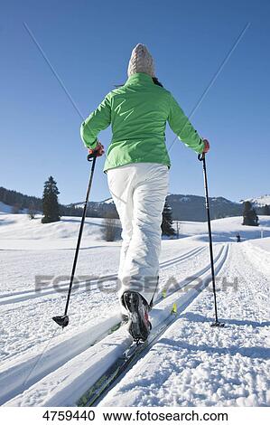 Stock Image - Woman cross-country skiing, Tannheimer Tal, Tyrol, Austria . Fotosearch