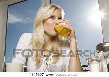 Woman drinking orange juice View Large Photo Image Stock Photo - Woman drinking orange juice . Fotosearch