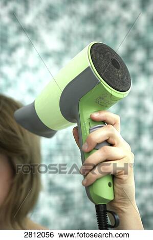Woman holding hair dryer View Large Photo Image Stock Photograph - Woman holding hair dryer . Fotosearch